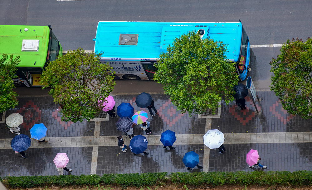 西安迎来降雨降温天气俯瞰上班族雨中撑伞行走