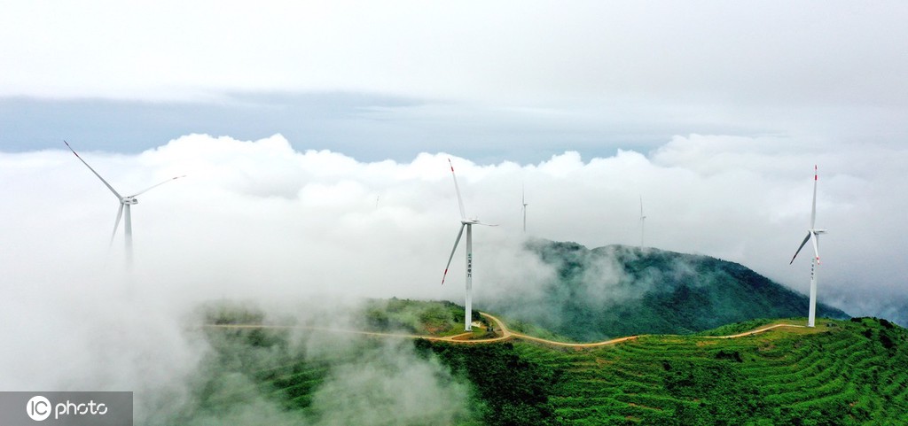 在海拔1000多米的浙江省台州市仙居县廿四尖背山巅,风力发电机在云雾