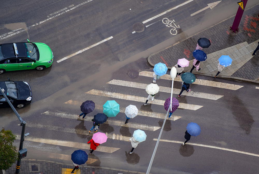 西安迎来降雨降温天气 俯瞰上班族雨中撑伞行走