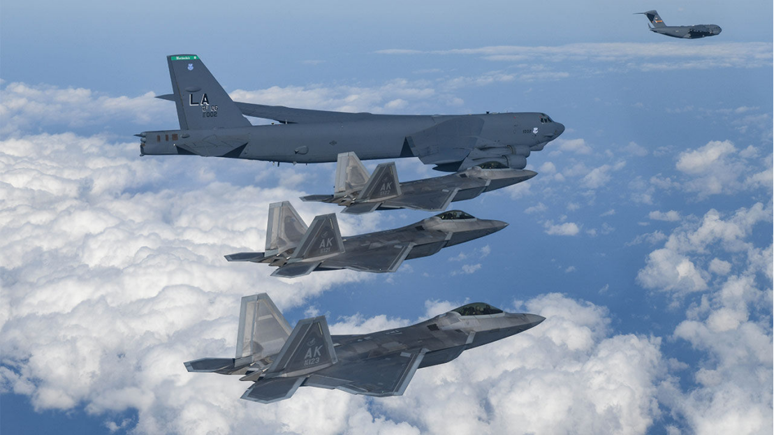 美国空军b-52h战略轰炸机,f-22"猛禽"战斗机,c-17运输机正在编队飞行