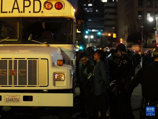 6月10日，在美国加利福尼亚州洛杉矶市中心，警察在宵禁生效后逮捕未及时离开的抗议者。新华社发（邱晨摄）