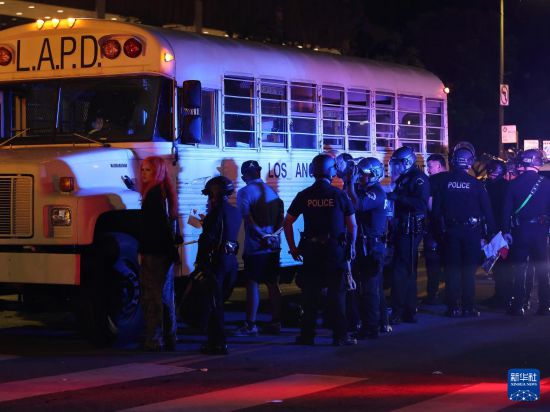 6月10日，在美国加利福尼亚州洛杉矶市中心，警察在宵禁生效后逮捕未及时离开的抗议者。新华社发（邱晨摄）