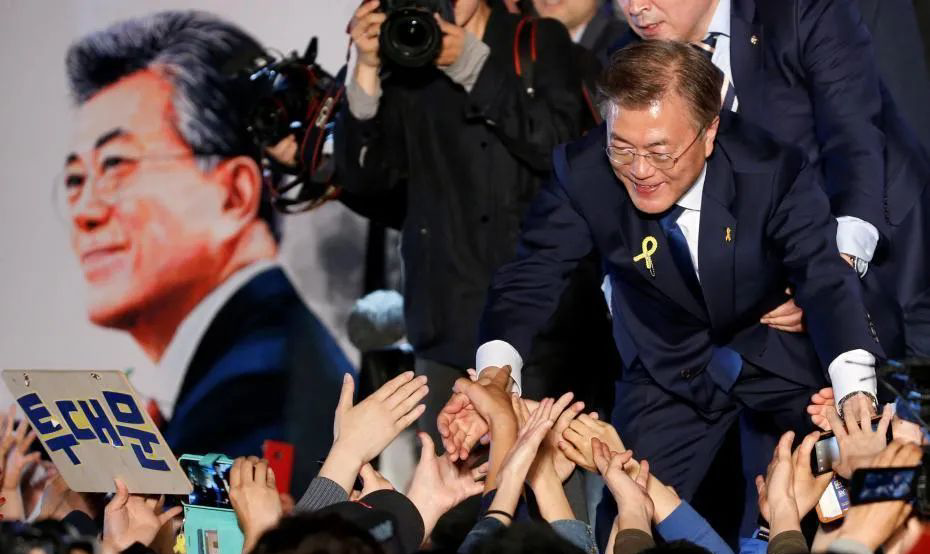 2017年5月,共同民主党候选人文在寅在第19届韩国总统选举中获胜,与民众握手庆祝。
