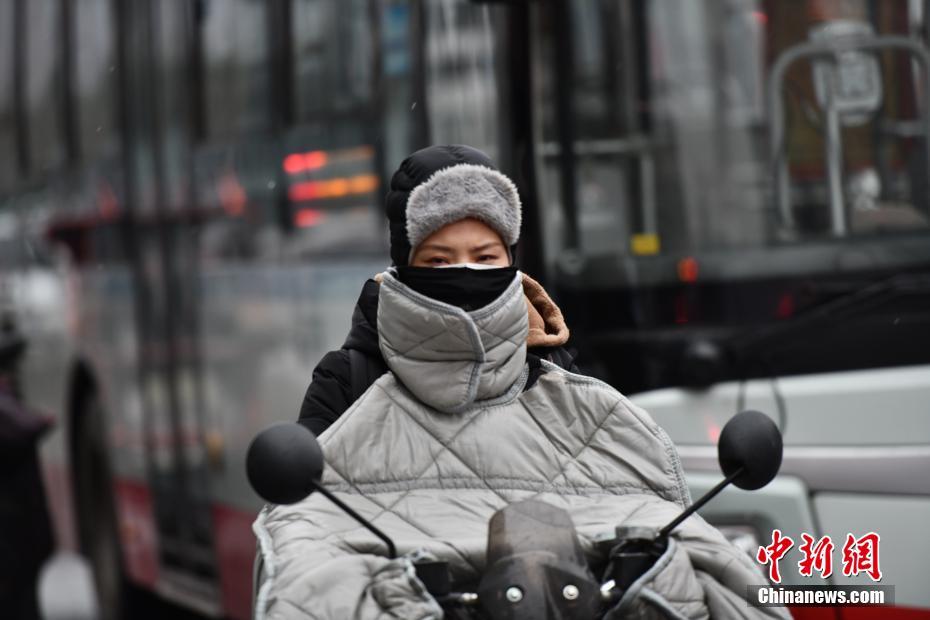 成都市区迎降雪降温天气市民全副武装出行