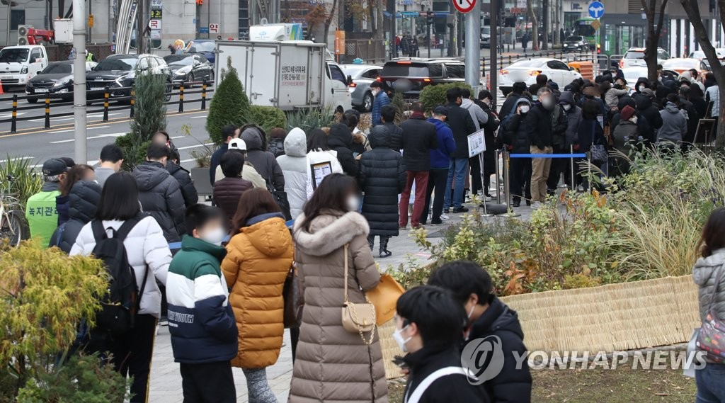 11月29日，在首尔市松坡区卫生站，市民排队接受核酸检测采样。图自韩联社