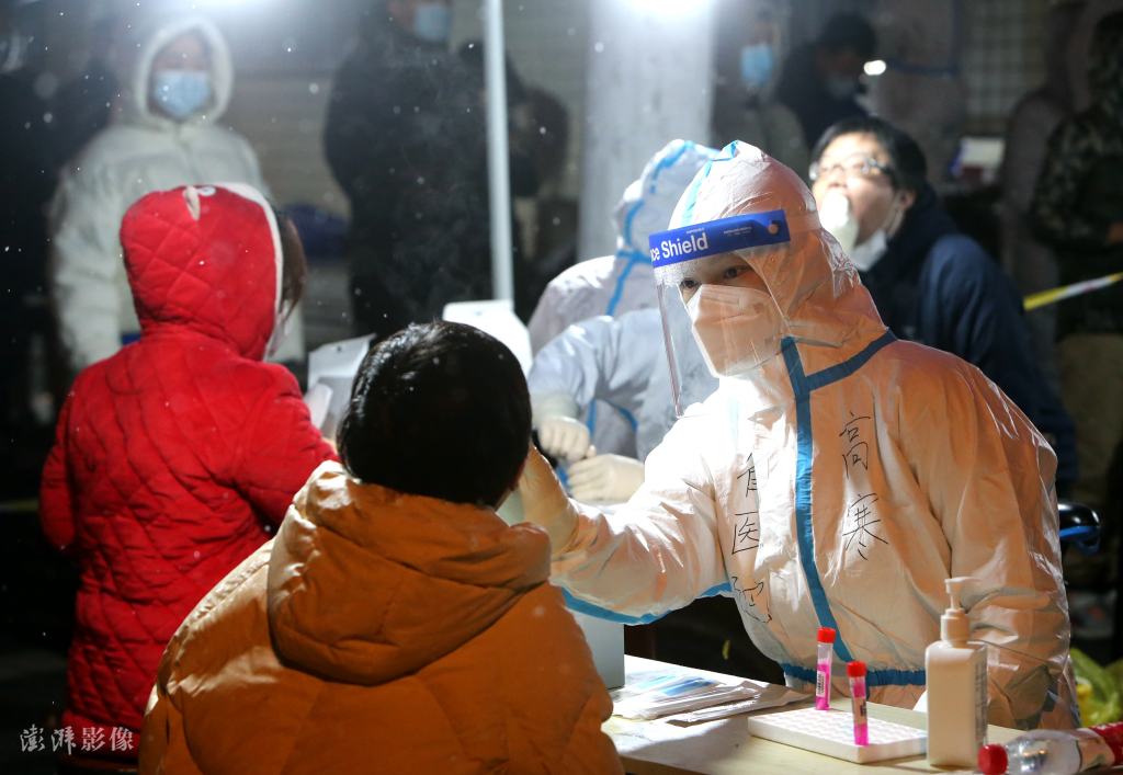 西安医护人员顶严寒冒飞雪为市民做核酸检测采样