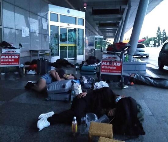 澎湖機場外，有民眾5天回不了家，一群人抱著行李箱睡覺。 圖自中時新聞網
