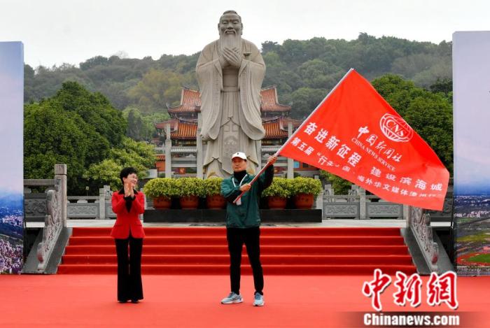 漳州市副市长余向红(左)向海外华文媒体代表授旗。吕明 摄