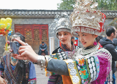 中外游客体验湘西苗族传统服饰。吴东林摄