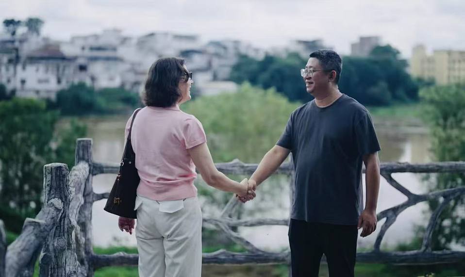 塔尼亚（左）和于都红军后人范京晔握手