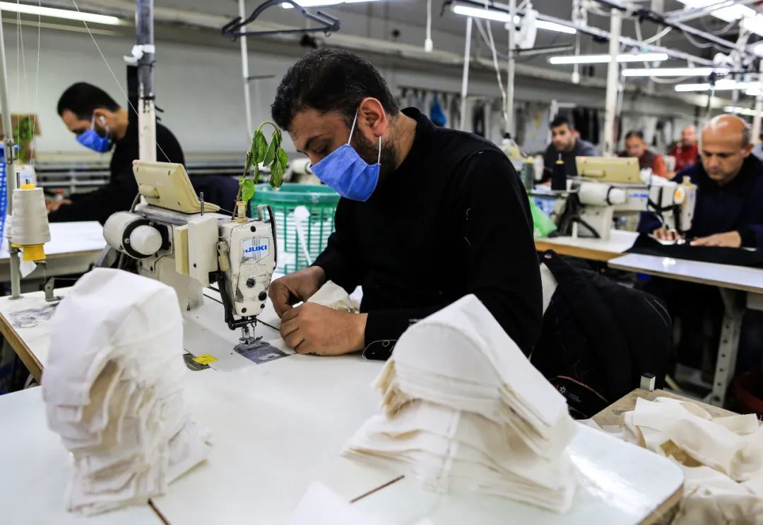 3月25日，在加沙城的一家工厂内，巴勒斯坦工人在生产医疗物资。新华社发（亚西尔摄）