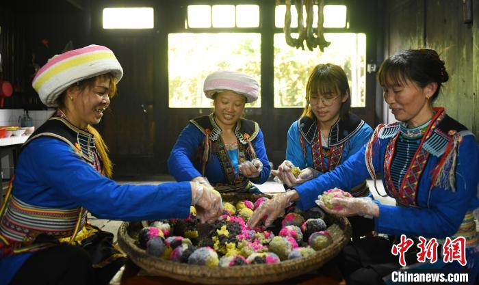 图为2024年“三月三”传统歌圩节到来之际，瑶族村民在捏制五色糯米团。潘志祥 摄