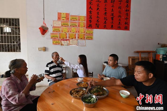 午饭期间，罗意兰为爷爷喂饭。 王以照 摄