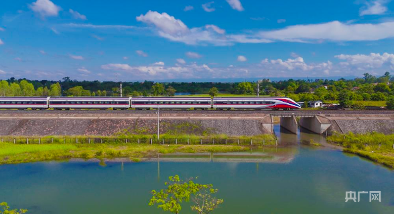 中老铁路D87次国际旅客列车奔驰在老挝万象（央广网发 杨永全 摄）