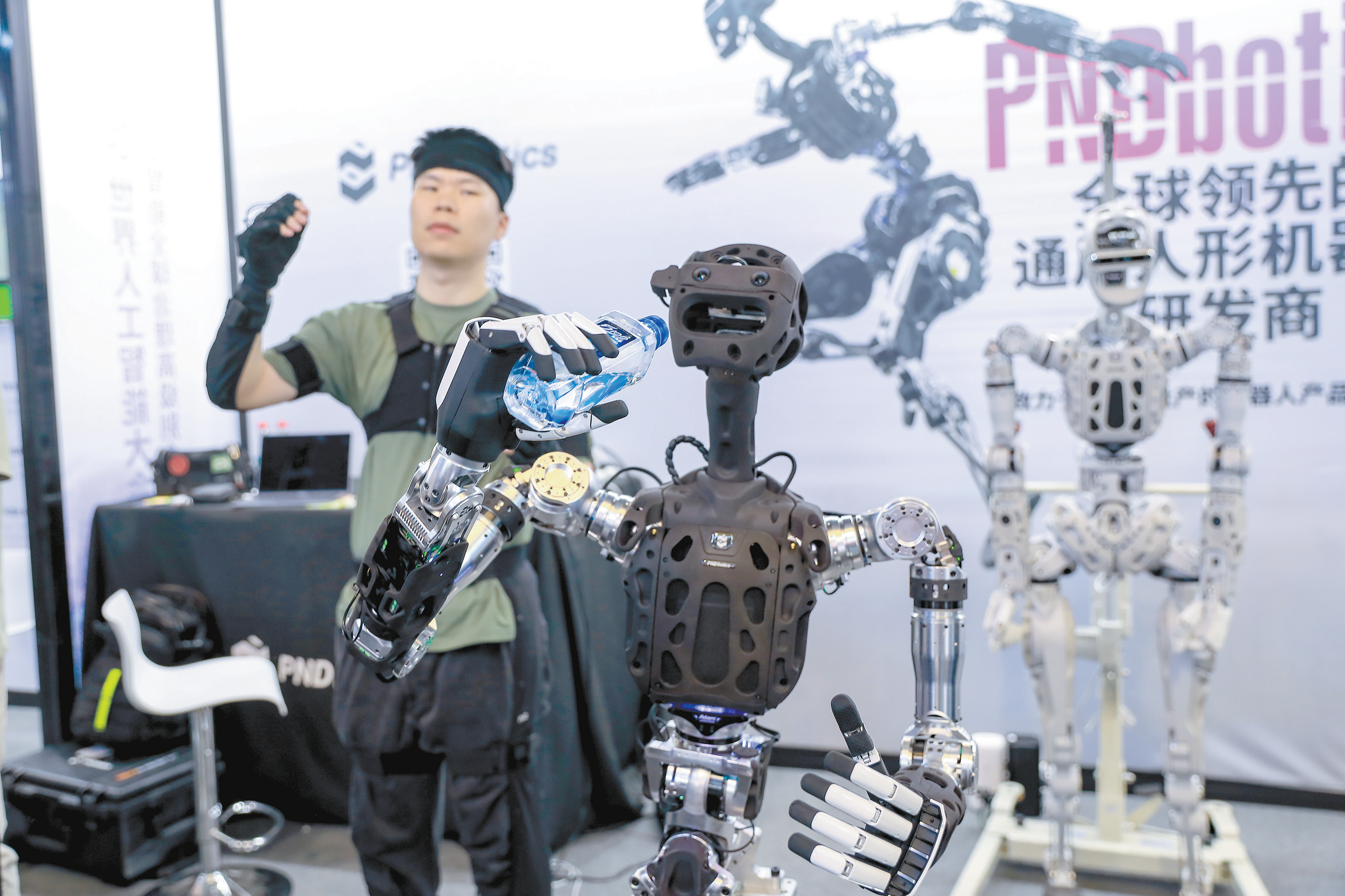 人形机器人被认为是具身智能的“终极形态”。图为7月29日世界人工智能大会上演示的人机协同作业。（视觉中国）