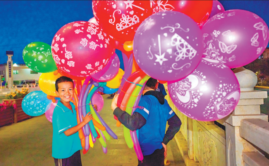 Students hold balloons for outing in Kashgar, Xinjiang Uygur autonomous region, on Aug 30, 2019. SHANG CHANGPING/FOR CHINA DAILY