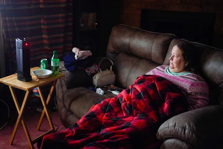 2月20日，美国得克萨斯州沃思堡，一名女子在断电的家中盖被取暖。新华社/路透