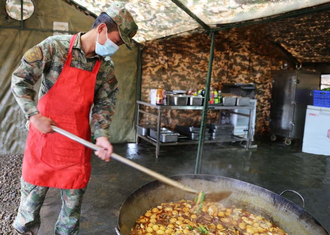 挥勺动铲，美味四溢。炊事员赵国栋准备会餐美食