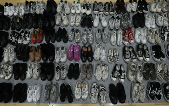 “梨泰院事故遗失物品招领处”中摆放着事故当晚死伤者遗失的鞋子。 图自韩媒
