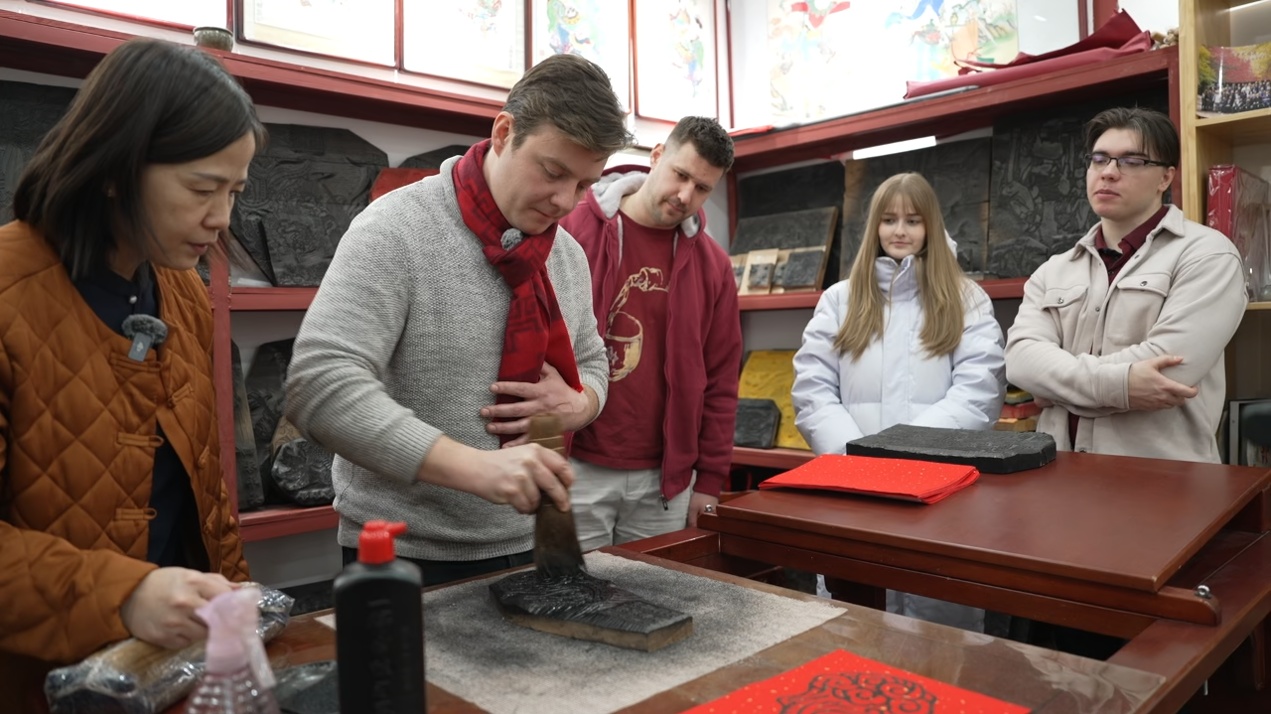 帝汉尼（左二）给匈牙利老乡们演示怎么拓年画