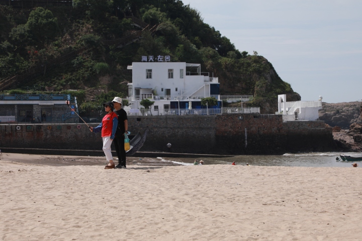 游客们在海边拍照打卡