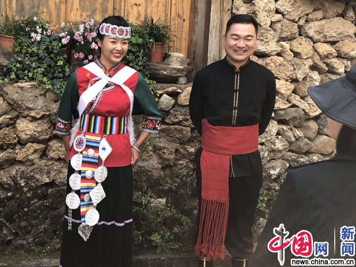 玉湖村居民身着民族服饰在村内与游客打招呼。中国网记者 严星／摄