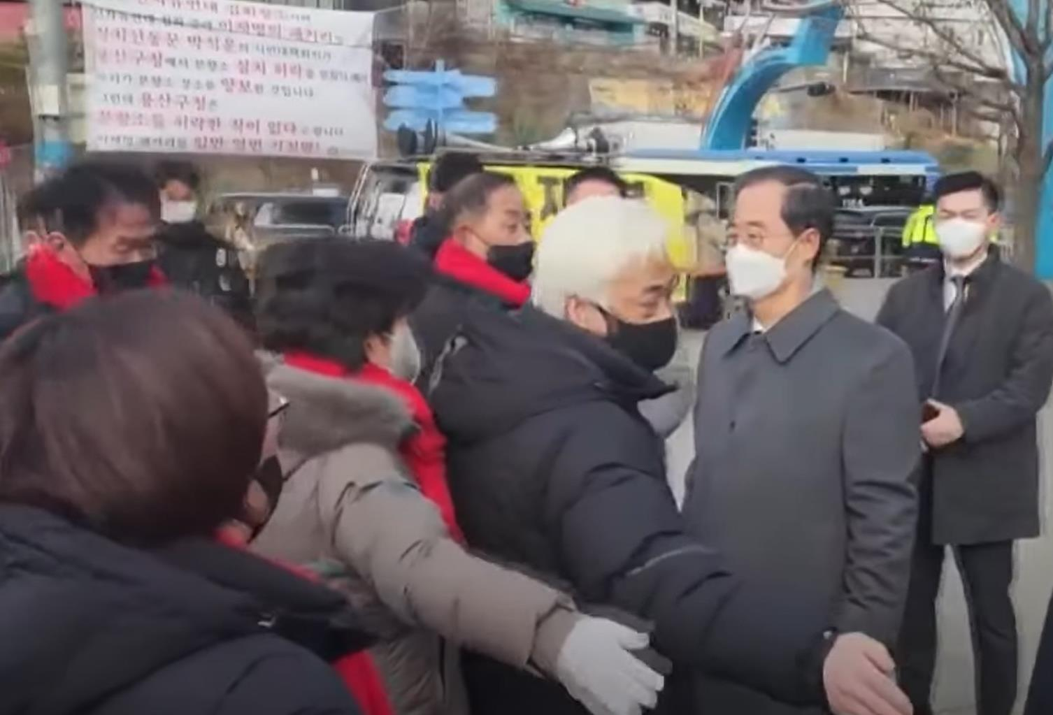 MBC报道截图:韩德洙(右二)在梨泰院事故遇难者吊唁场所遭到相关遗属的抗议和反对。