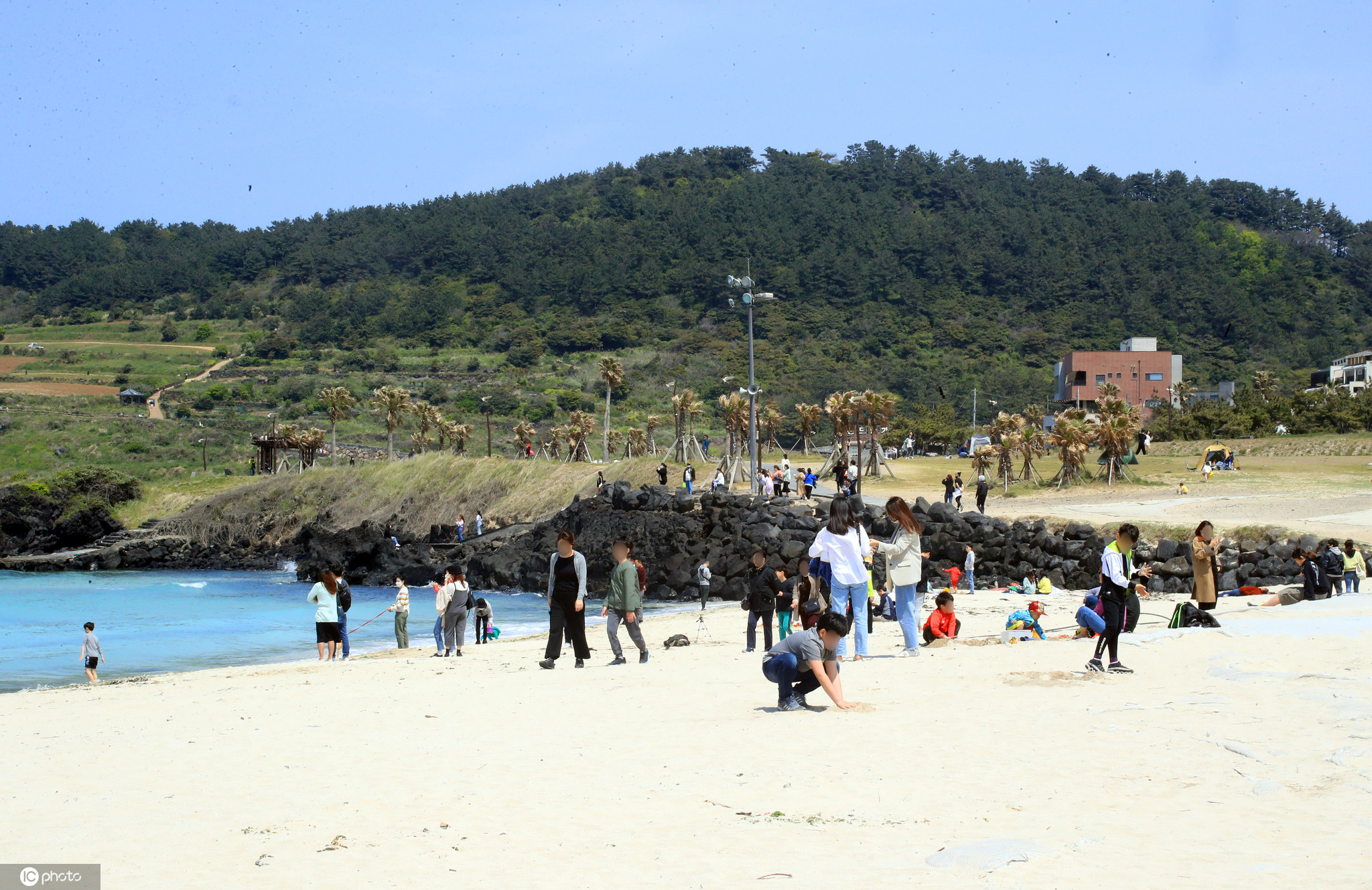 韩国济州岛天气转暖游人在海水浴场冲浪