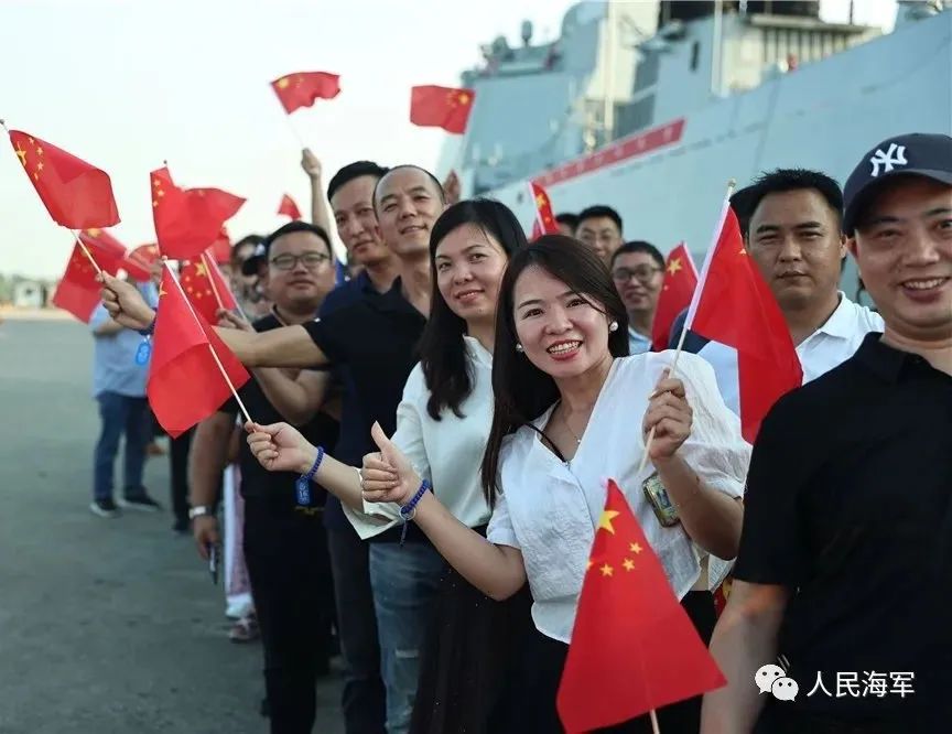 图为码头欢迎人群挥舞五星红旗排队参观舰艇 方思航 摄