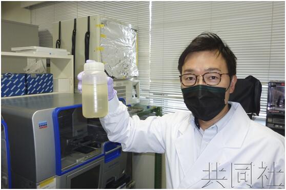 北海道大学副教授北岛正章手拿新冠病毒调查的下水道样本。4月摄于札幌市。图自共同社