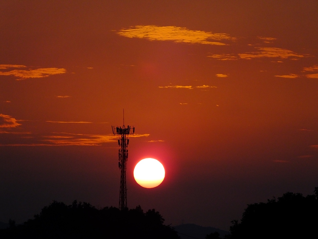 湖北宜昌日出红太阳与通信铁塔相映成趣