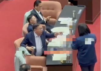 王义川拿水杯大力敲桌子。图源：台媒报道视频截图