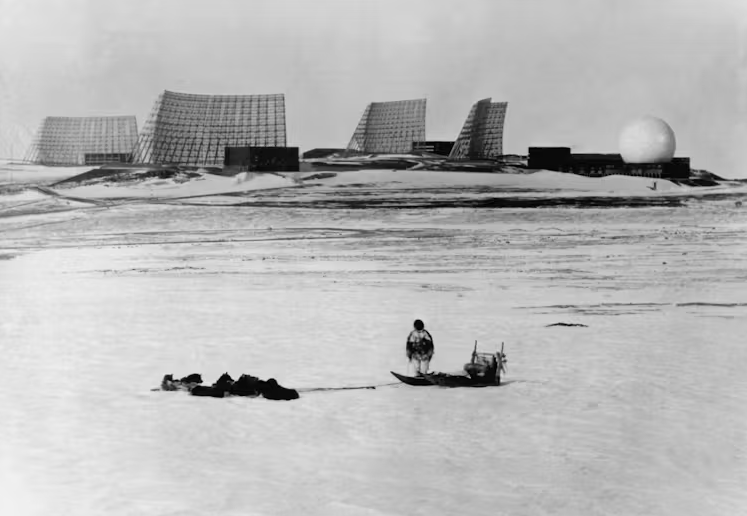 1966年，驾着狗拉雪橇的格陵兰岛居民看向美国图勒空军基地。