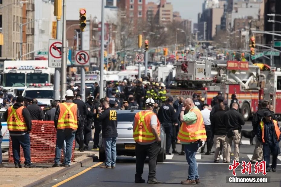 当地时间4月12日，美国纽约市布鲁克林区36街地铁站发生枪击案，至少16人受伤，其中10人直接中枪，大批警力和相关部门人员赶赴现场。图为地铁站外的地铁工作人员。