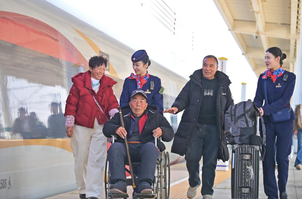 2月14日，在河南兰考南站，来自河南开封杞县的旅客程先生（右二）带着爱人、老父亲准备乘坐G6685/G376次列车赶赴北京，与孩子团聚。新华社发（王玮 摄）