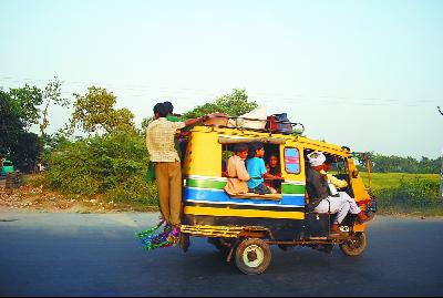 新德里郊外,印度民众搭乘“突突车”出行。