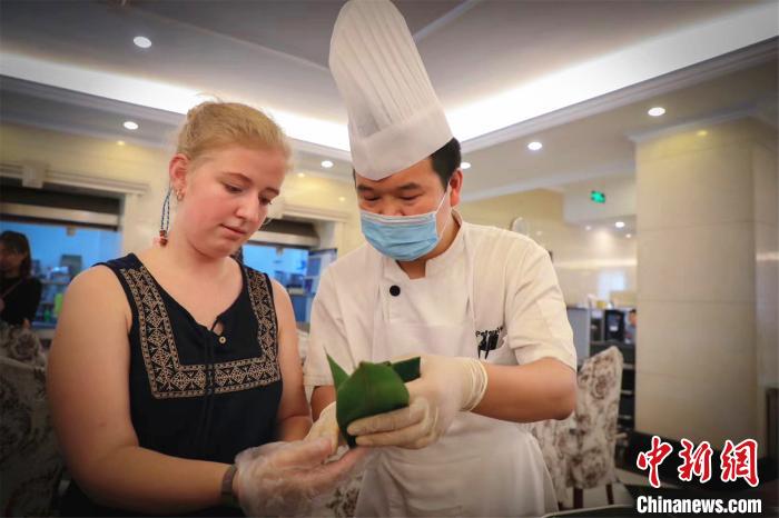 郑州西亚斯学院外教老师及家属包粽子体验中国传统文化 肖胜春 摄