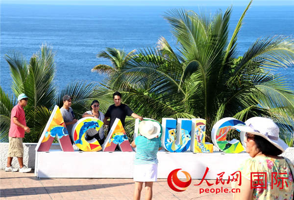 游客在海滨“ACAPULCO”字样前留影 于世文 摄