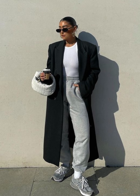 同样的穿搭公式,黑白灰三色经典不出错,单手挎包握着咖啡,脚上的new