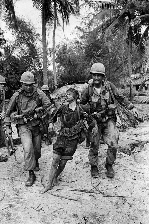 1966年1月29日，两个美军士兵在越南平定省北部粗暴抓走一名越共游击队战士。