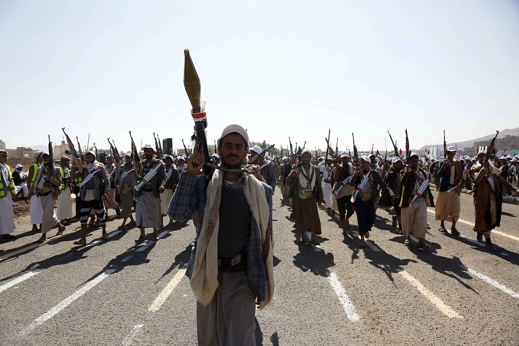 12月20日，数千名完成军事训练的胡塞武装人员手持武器在也门阿姆兰省参加阅兵式。（视觉中国）