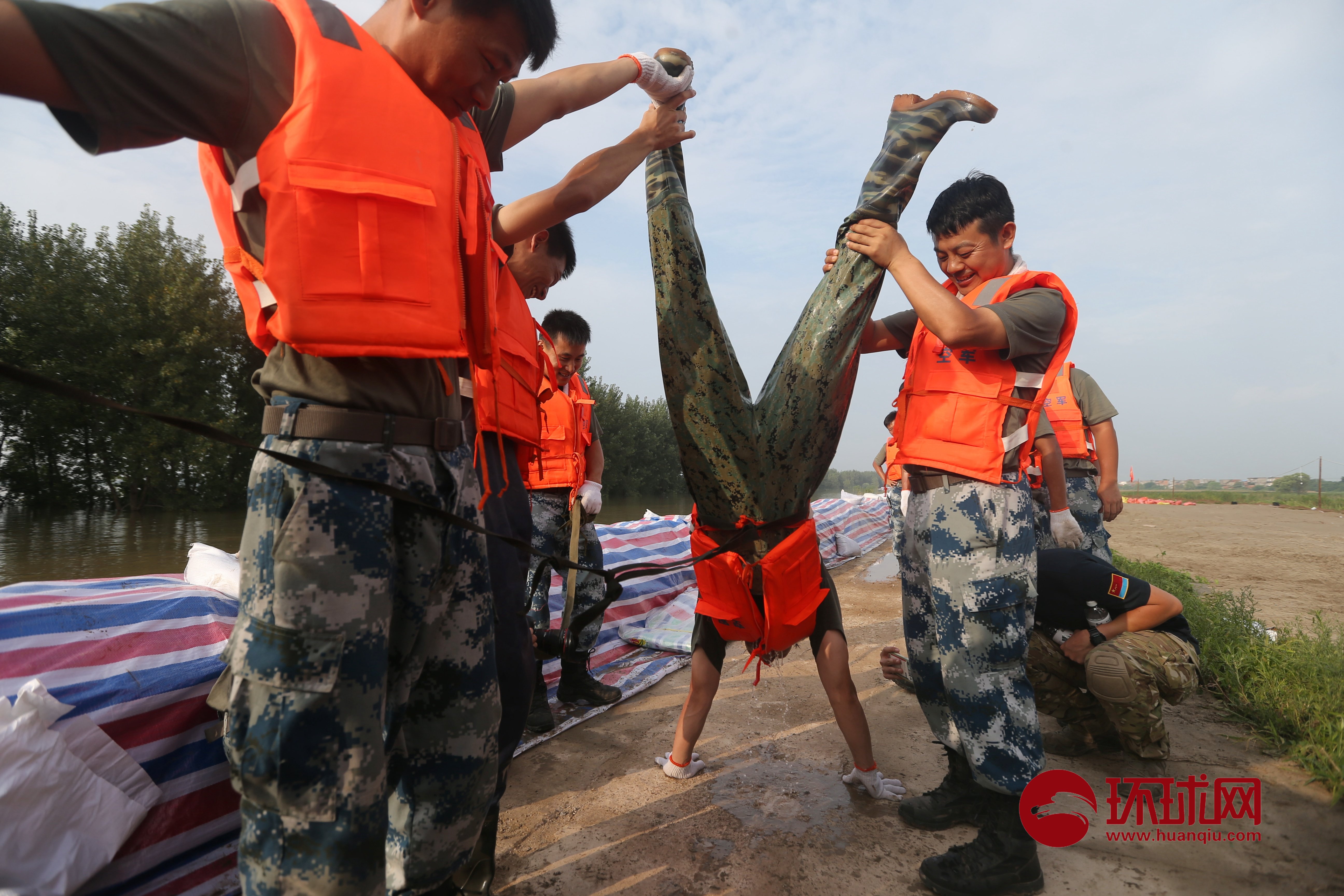 江西九江抗洪战士加固圩堤上水后被倒控灌进防水裤中的江水