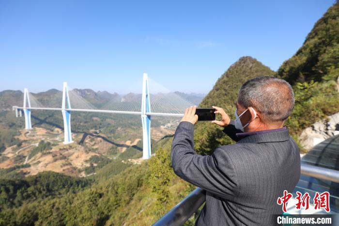 11月2日，贵州平塘，游客在“天空之桥”服务区观景台拍摄“平塘特大桥”。 瞿宏伦 摄