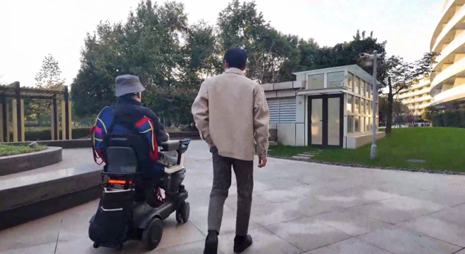 图为高位截瘫患者（左）通过脑智卓越中心等单位研发的脑机接口系统意念控制轮椅。（图片来源：中国科学院脑科学与智能技术卓越创新中心）