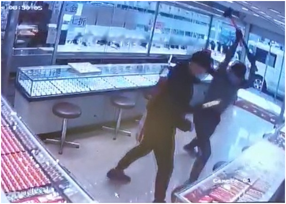 两名劫匪分别持铁锤和牛肉刀砸毁珠宝店柜台。（图源：“东网”）