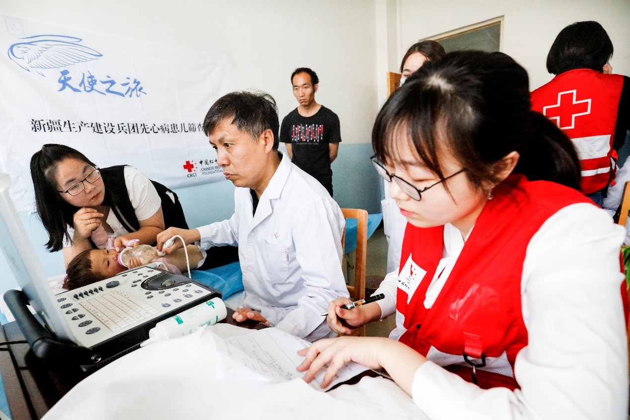 在新疆图木舒克,中国红基会医生志愿者在对当地儿童开展先心病患儿筛查救助行动