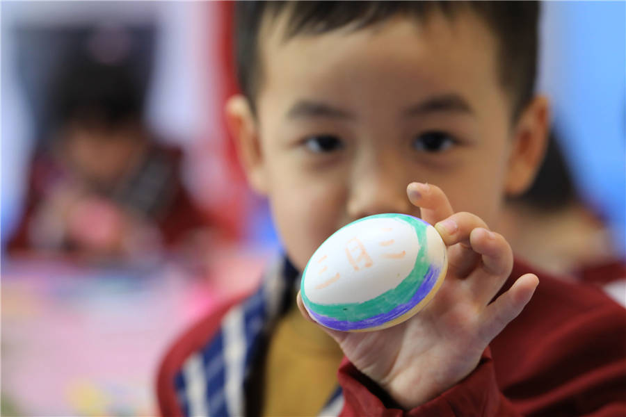 A child shows a painted egg made for Shangsi Festival at a kindergarten in Hengyang county, Hunan province on April 18, 2018. [Photo/IC]