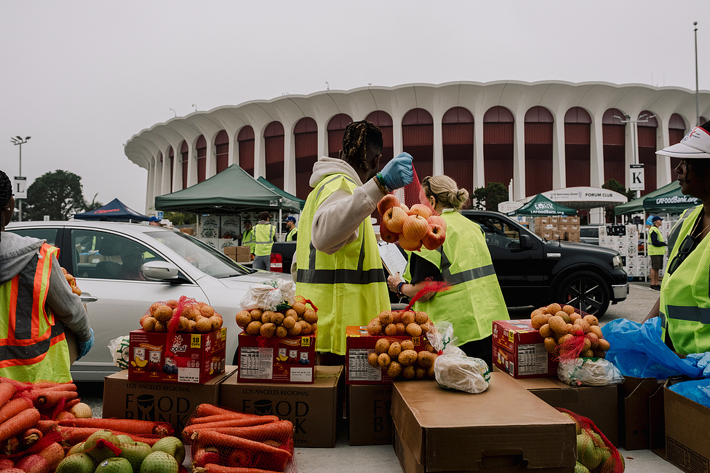 11月1日,食品银行志愿者向洛杉矶居民派发捐赠食物。(视觉中国)