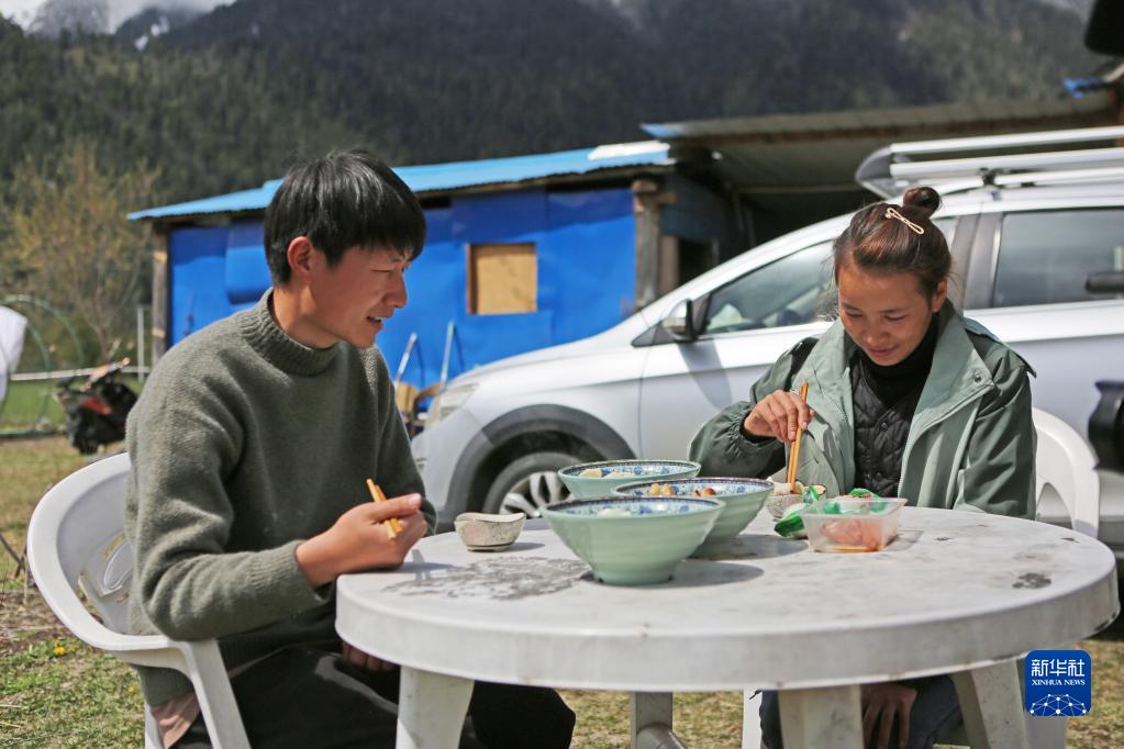 3月24日，白玛德吉和丈夫殷合在民宿门前吃饭。 新华社记者 格桑朗杰 摄