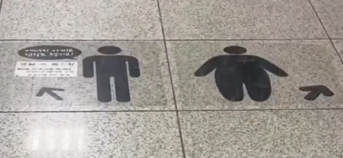 左边的明显较瘦,指向楼梯,右边的较胖,指向自动扶梯。